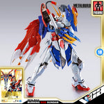 Metal Build Burning God Gundam figure in a dynamic pose, featuring a white, blue, and red color scheme with gold accents, set against a light gray background with product branding and packaging graphics.
