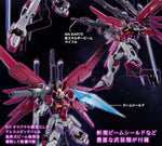 A Japanese promotional graphic for a Gundam model kit showing multiple views of a pink and white mobile suit with large wing-like arm pieces and blue beam shield accessories, set against a dark starry background with explanatory text callouts.